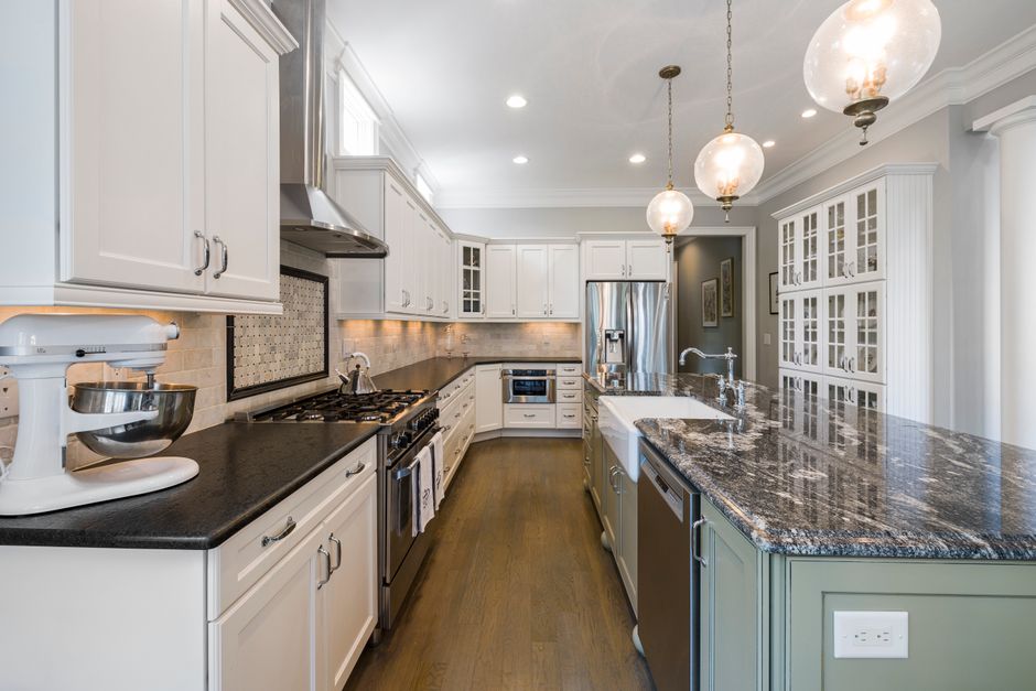 Spacious contemporary kitchen featuring marble island and pendant lighting.