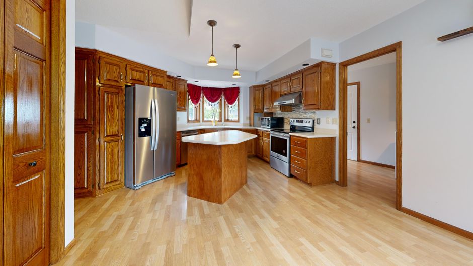 Spacious kitchen featuring wooden cabinetry and modern stainless-steel appliances.